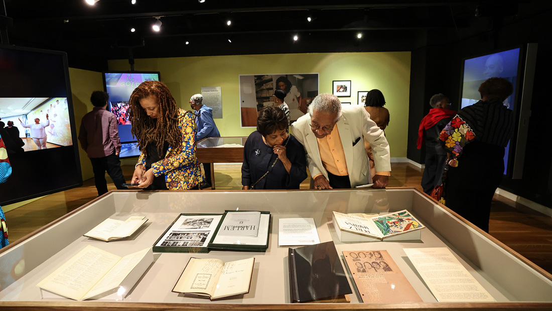 Visitors engaging with a historical exhibition focused on Harlem.